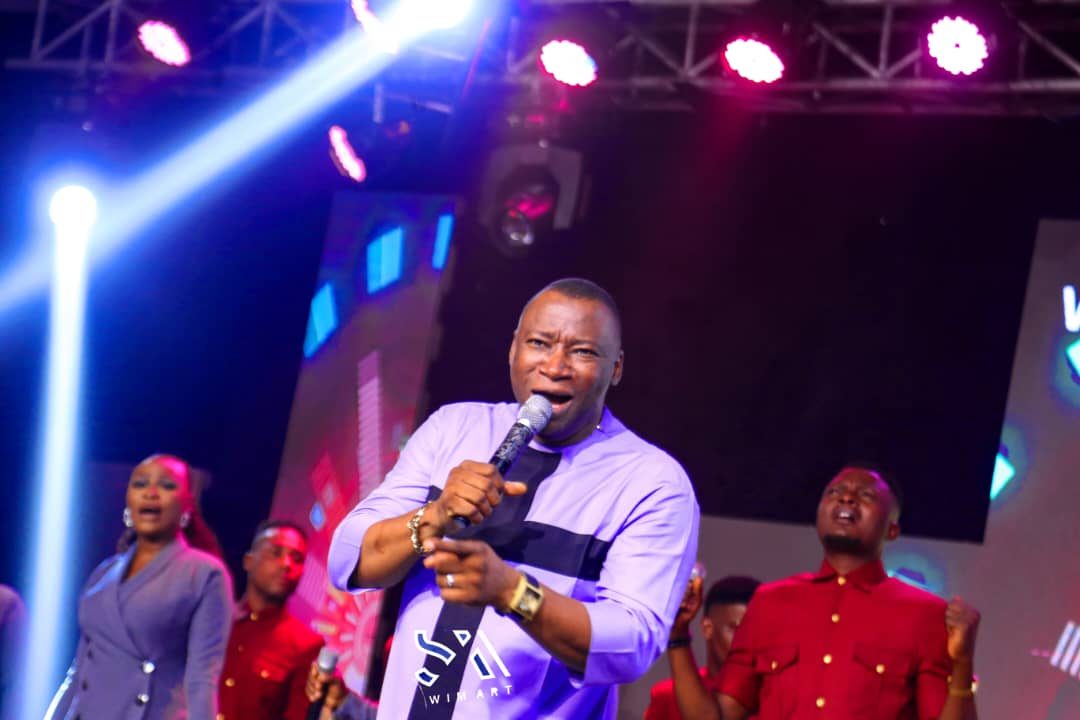 Rev. Victor Atenaga leading worship with a band